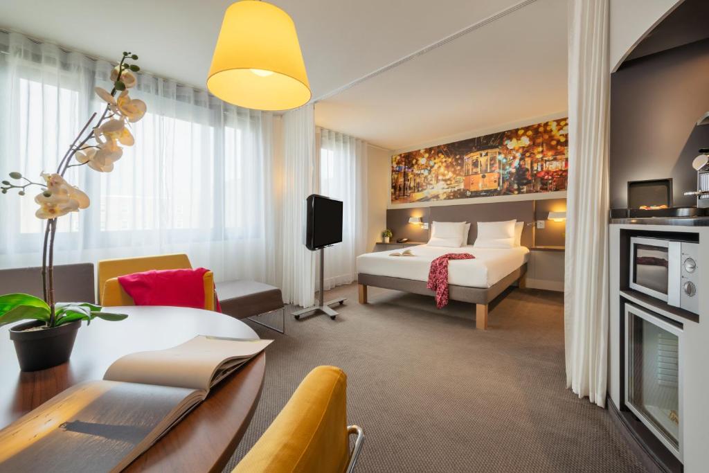 ロワシー・アン・フランスにあるノボテル スイート パリ CDG エアポート ヴィルパントのベッドとデスクが備わるホテルルームです。