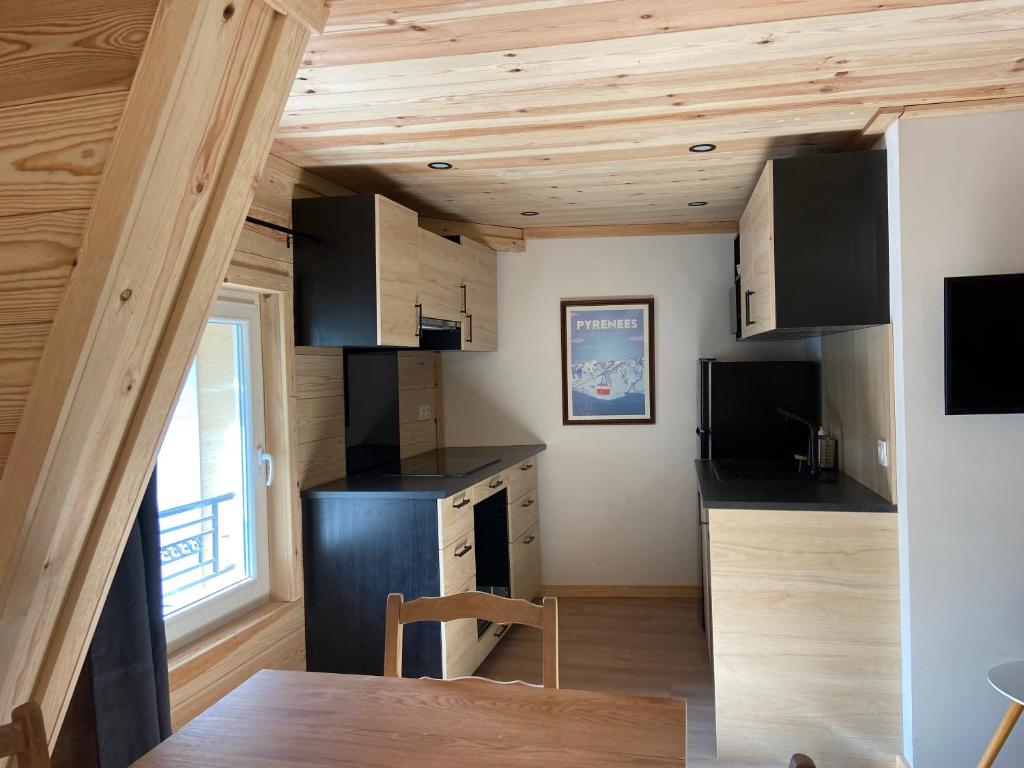kuchnia z drewnianym sufitem i drewnianym stołem w obiekcie Magnifique T3, en plein centre du village w mieście Formiguères