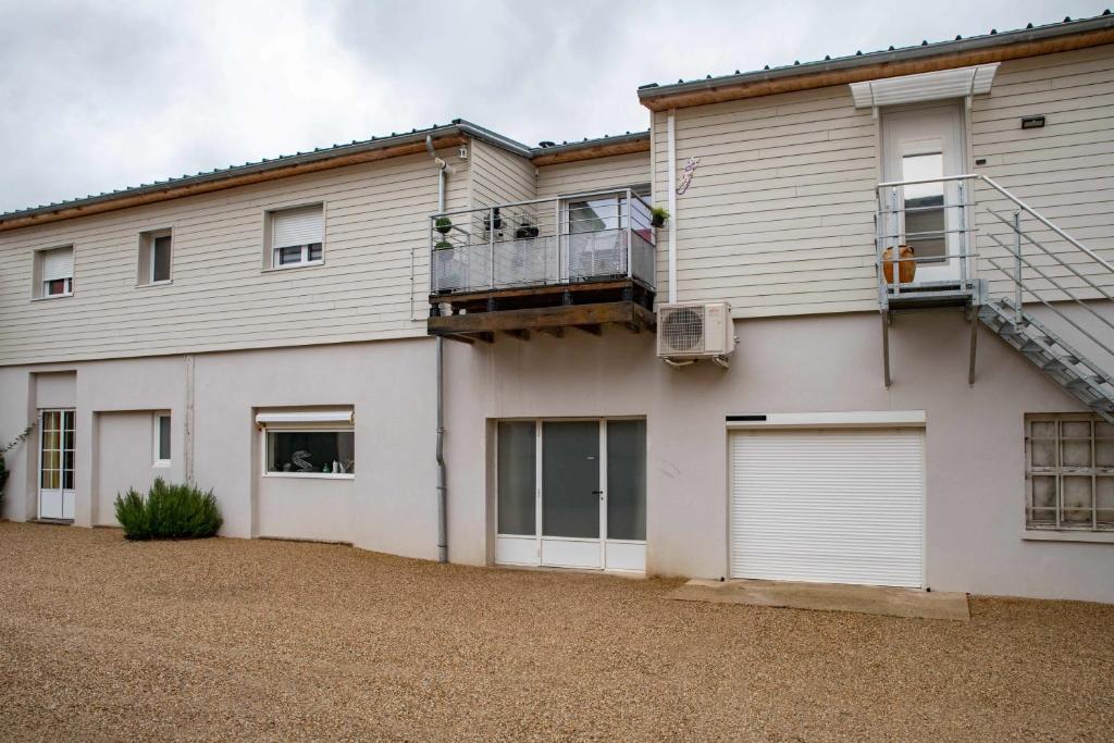 a house with two garage doors and a balcony at Résidence Epinat - Appartements centre & parking in Vichy