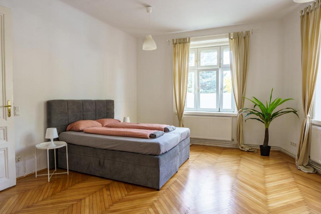 Vienna Living Apartments - Schönbrunn في فيينا: غرفة نوم مع سرير وزرع الفخار