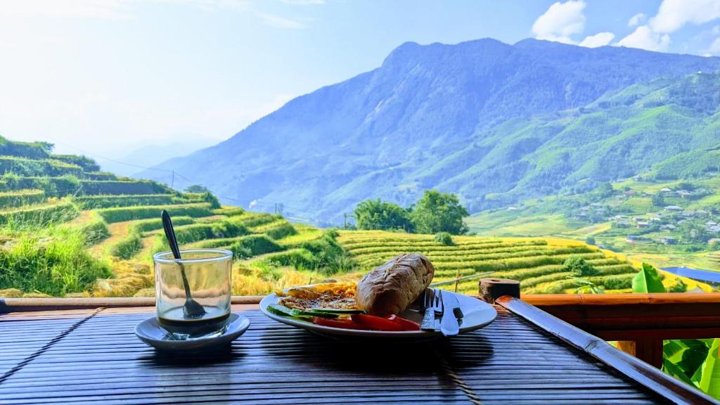 una tavola con un piatto di cibo e un bicchiere di vino di Surelee Homestay a Sa Pa