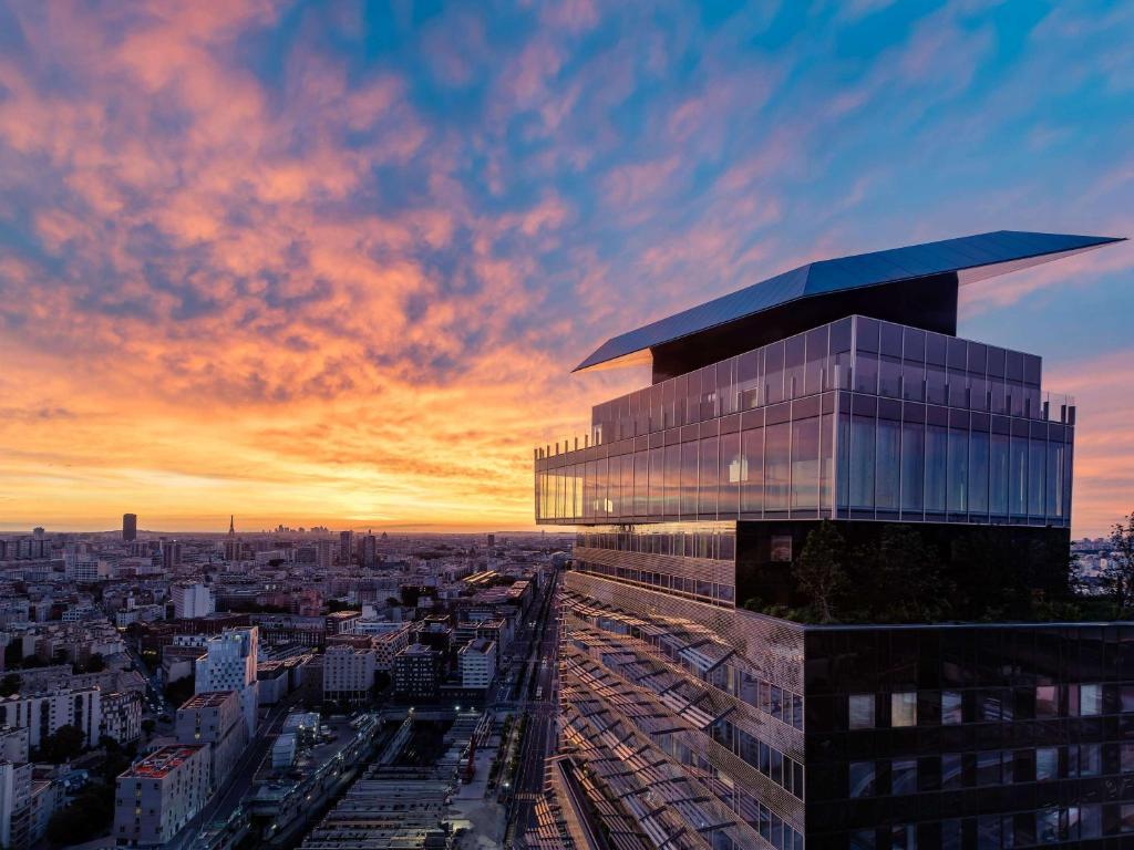 a view of a building with a sunset in the background at Too Hotel Paris - MGallery in Paris