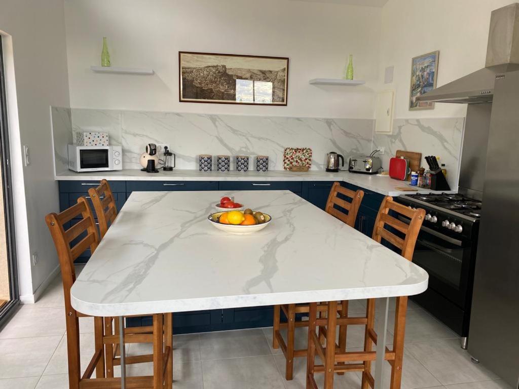 a kitchen with a table with a bowl of fruit on it at Maison de 2 chambres avec piscine privee jardin amenage et wifi a Bruniquel in Bruniquel