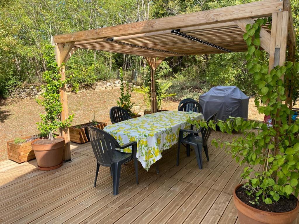 a wooden deck with a table and chairs and a pergola at Maison de 2 chambres avec piscine privee jardin amenage et wifi a Bruniquel in Bruniquel