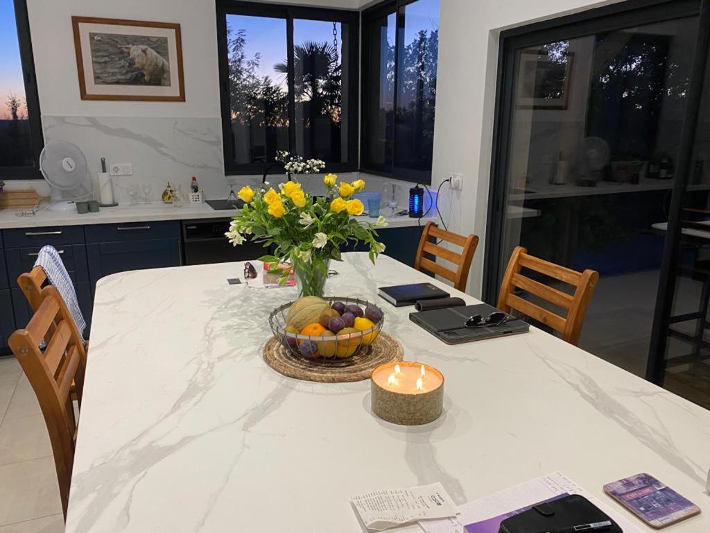 a table with a bowl of fruit and a candle on it at Maison de 2 chambres avec piscine privee jardin amenage et wifi a Bruniquel in Bruniquel