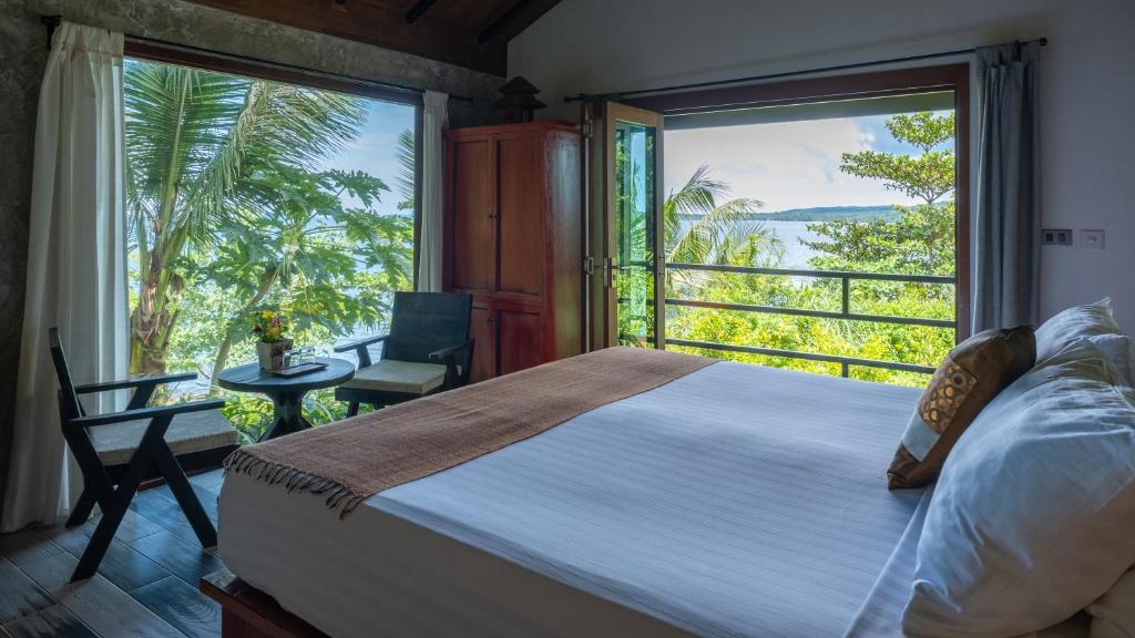 a bedroom with a bed and a large window at Jasmin Garden Koh Kood in Ko Kood