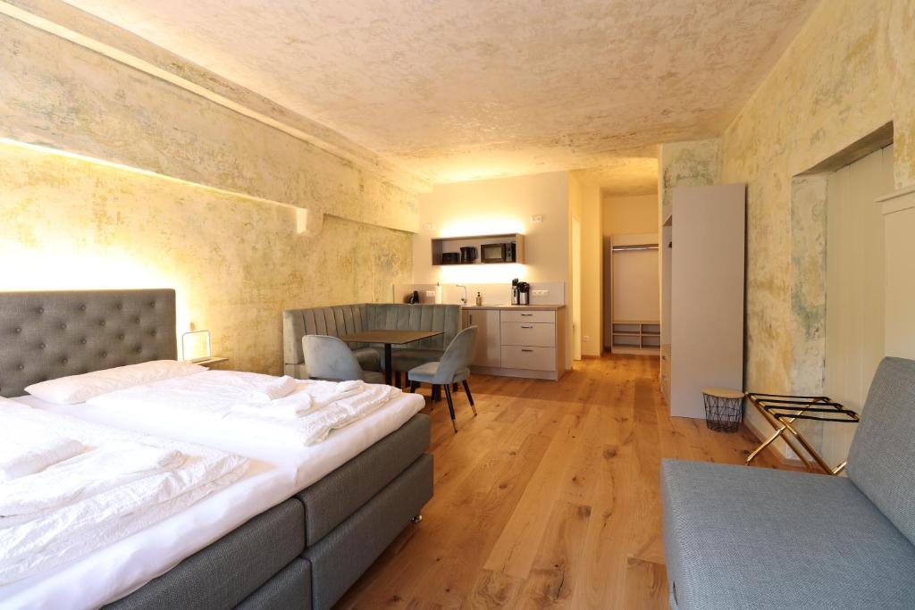 a bedroom with a bed and a table and a kitchen at Das Fischer Boardinghouse KF in Kaufbeuren