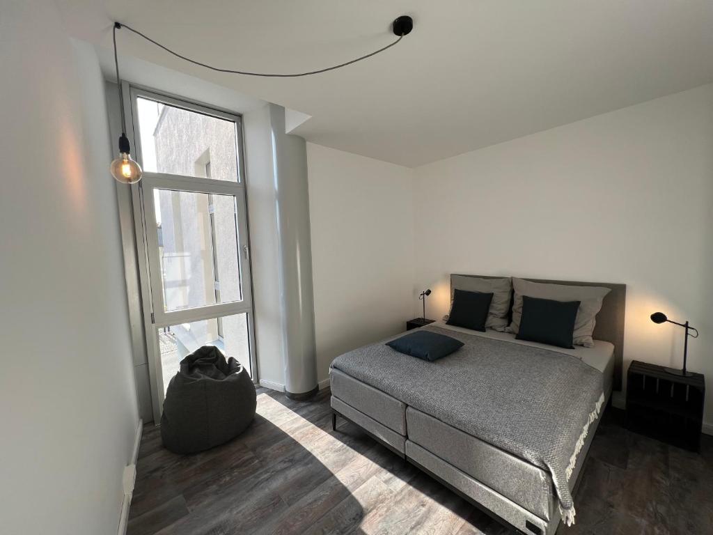 ein Schlafzimmer mit einem Bett und einem großen Fenster in der Unterkunft Apartmenthaus Sassnitz Zum Stadthafen Apartment 2 in Sassnitz