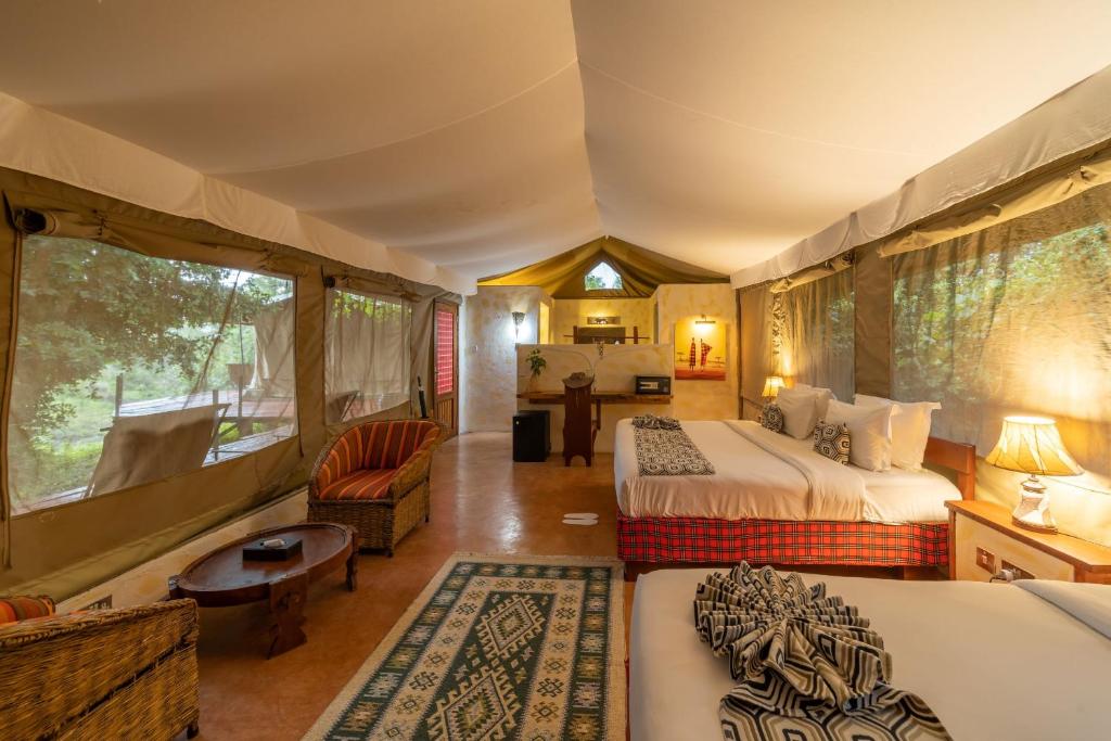 sypialnia z 2 łóżkami i kanapą oraz pokój w obiekcie PrideInn Mara Camp & Cottages w mieście Talek