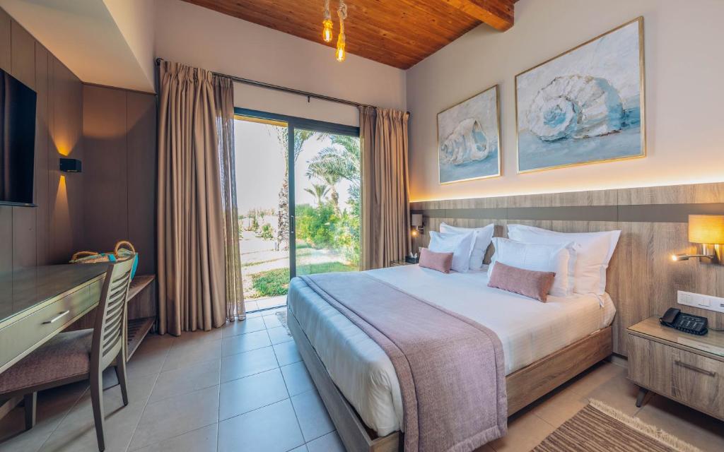 a bedroom with a large bed and a large window at Iberostar Waves Mehari Djerba in Taguermess