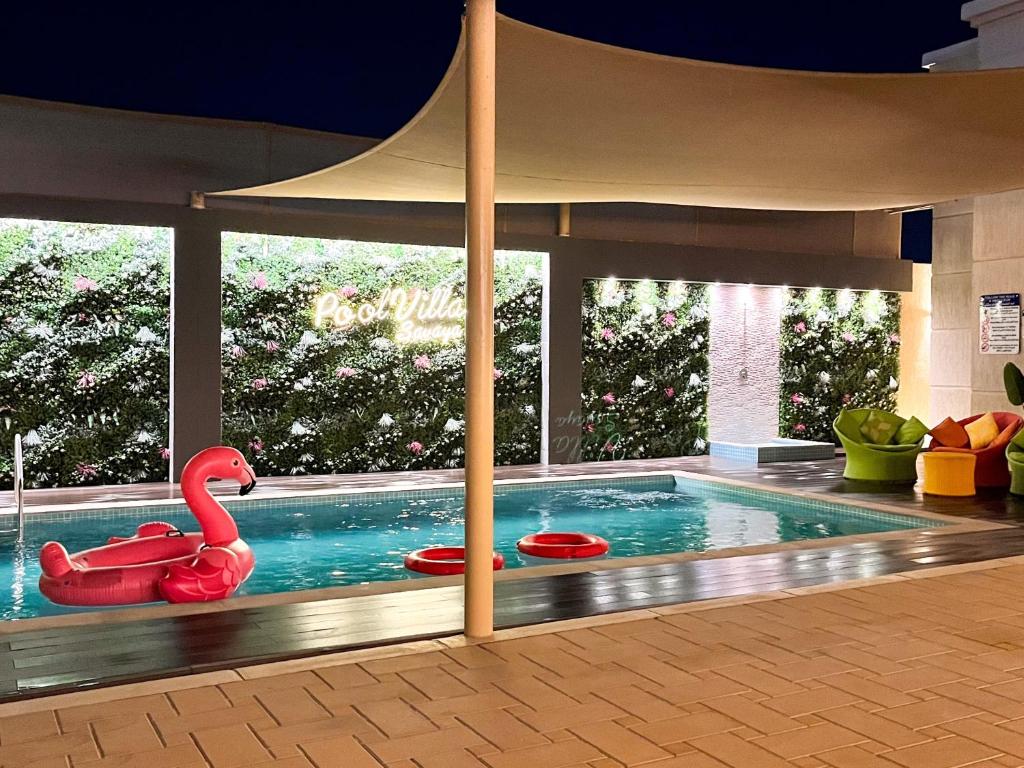 una piscina con un cisne rojo en un edificio en Pool Villa Saraya, en Ras al Khaimah