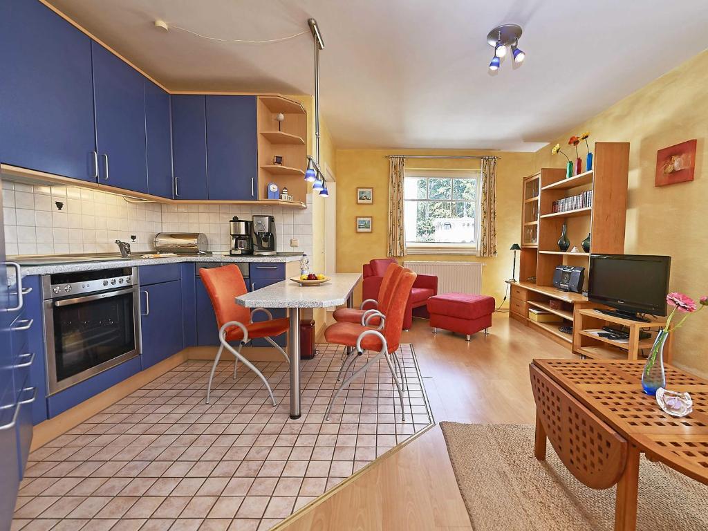 una cucina con armadi blu, tavolo e sedie di Villa Li - Fewo 10 - F546 a Ostseebad Sellin