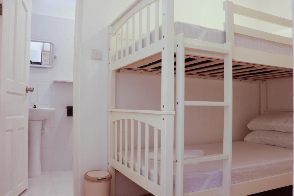 - białe łóżko piętrowe w niewielkim pokoju z łazienką w obiekcie Paradisola w mieście Fodhdhoo