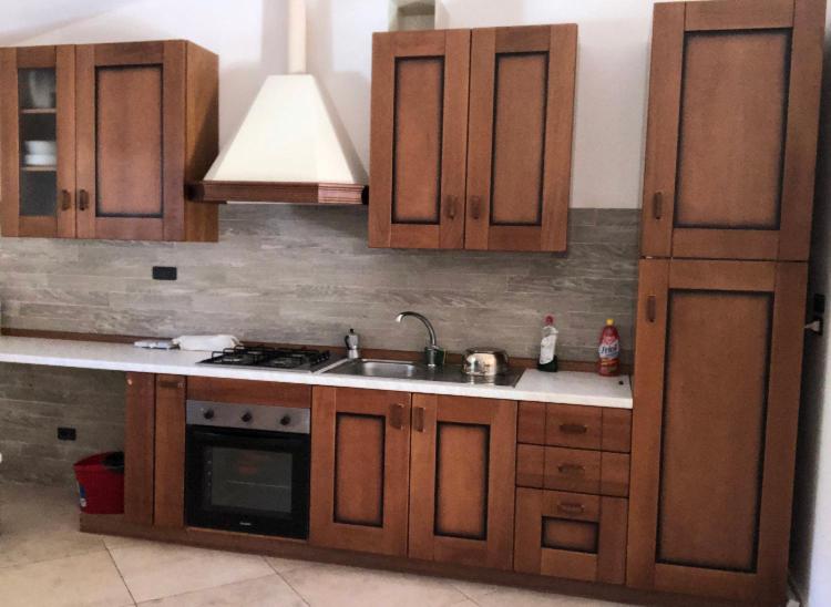 a kitchen with wooden cabinets and a sink at Appartamento Diana in Roccaraso