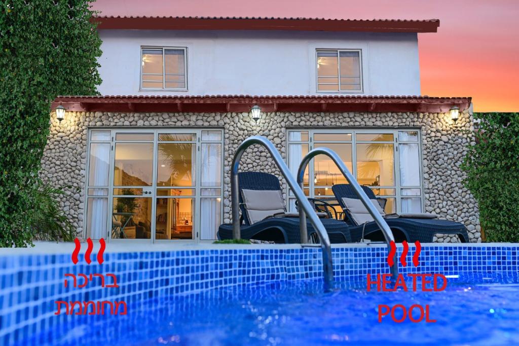a swimming pool in front of a house at Villa Yotam Heated pool וילה יותם בריכה מחוממת in Eilat