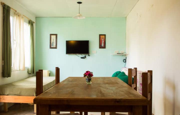une salle à manger avec une table en bois et une télévision dans l'établissement Patagonia Beach Las Grutas!, à Las Grutas