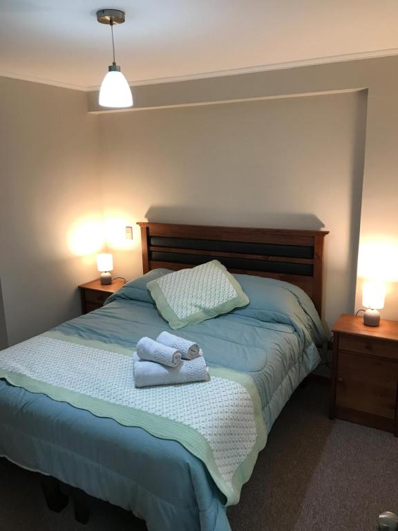 1 dormitorio con 1 cama con 2 toallas en Departamento en Pelluco, Puerto Montt, en Puerto Montt