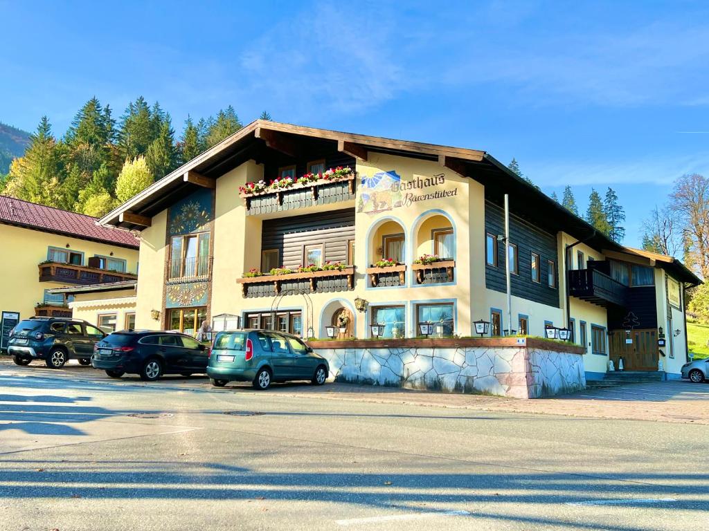 budynek z samochodami zaparkowanymi na parkingu w obiekcie Hotel Bärenstüberl w mieście Schönau am Königssee