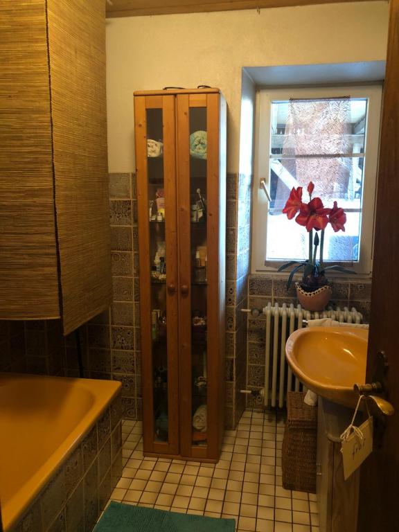 een badkamer met een bad, een wastafel en een kast bij Trad. Blackforest House in Ettenheim