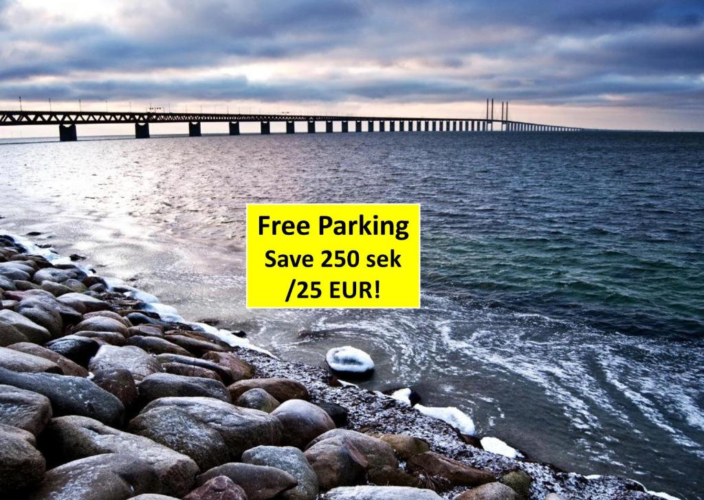 a sign on a beach with a pier in the water at Beautiful location Copenhagen/Malmö in Malmö