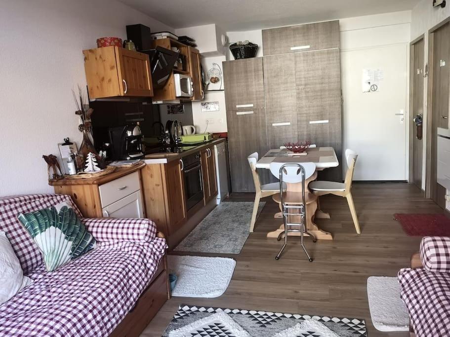 sala de estar con sofá, mesa y cocina en Auron, 2 pièces meublé, coin montagne,6 couchages, en Auron