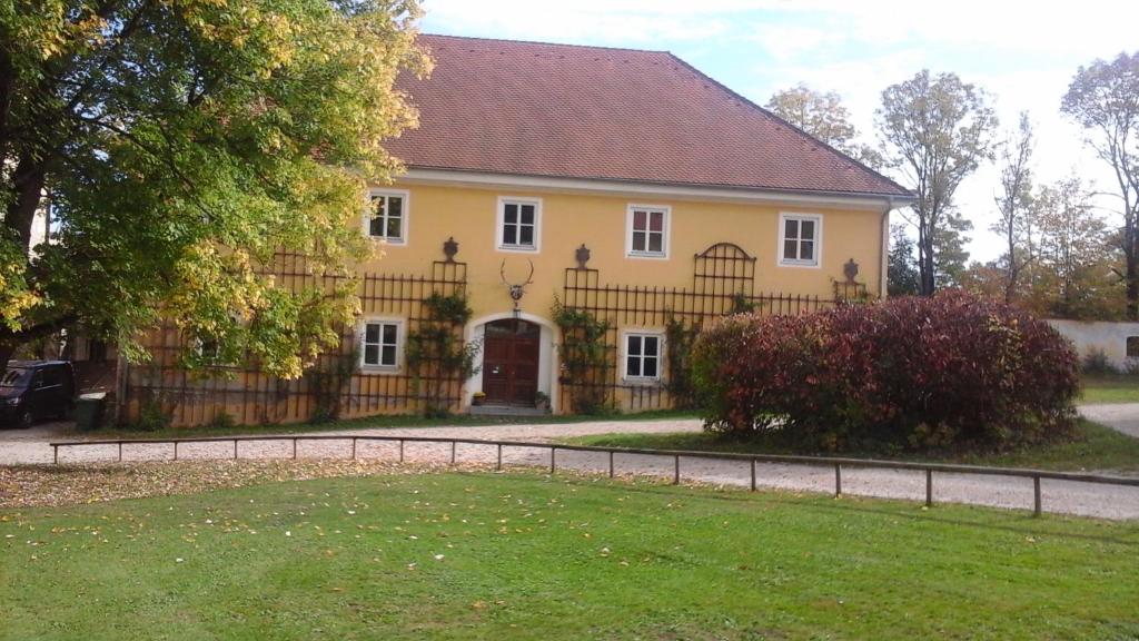 Jetzendorf的住宿－Schloss Jetzendorf, Verwalterhaus，前面有栅栏的黄色房子