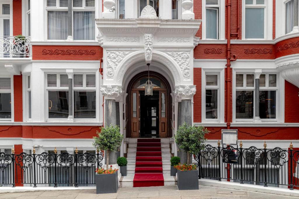 een rood-wit gebouw met een deur en een trap bij Althoff St James's Hotel & Club London in Londen