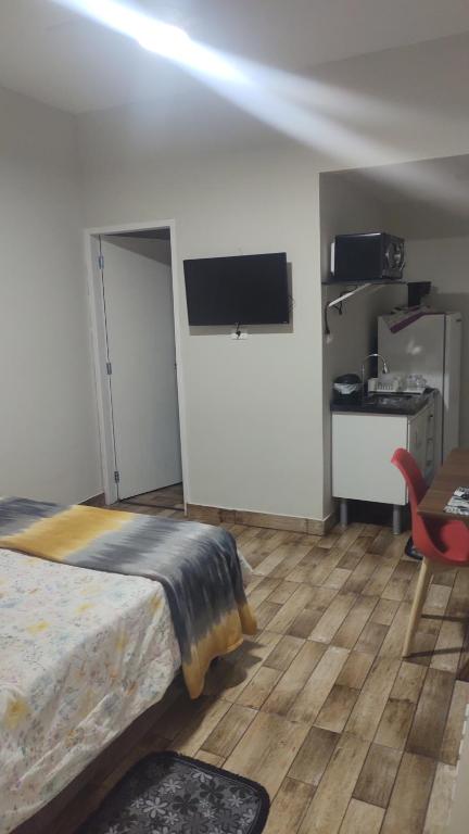 Dormitorio con cama, escritorio y TV en Catumbi Studio 5, en São Paulo