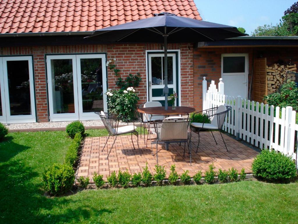 a patio with a table and an umbrella in a yard at "Rosenkate 2" in Riepsdorf