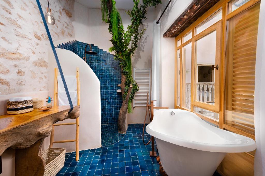 a bathroom with a white tub and blue tiles at Mama Lova Hôtel, Riad, Restaurant & Spa in Essaouira