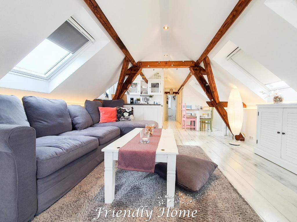 a living room with a couch and a table at Friendly Home - "Helles Dachstudio" Köln Bonn Phantasialand in Bornheim