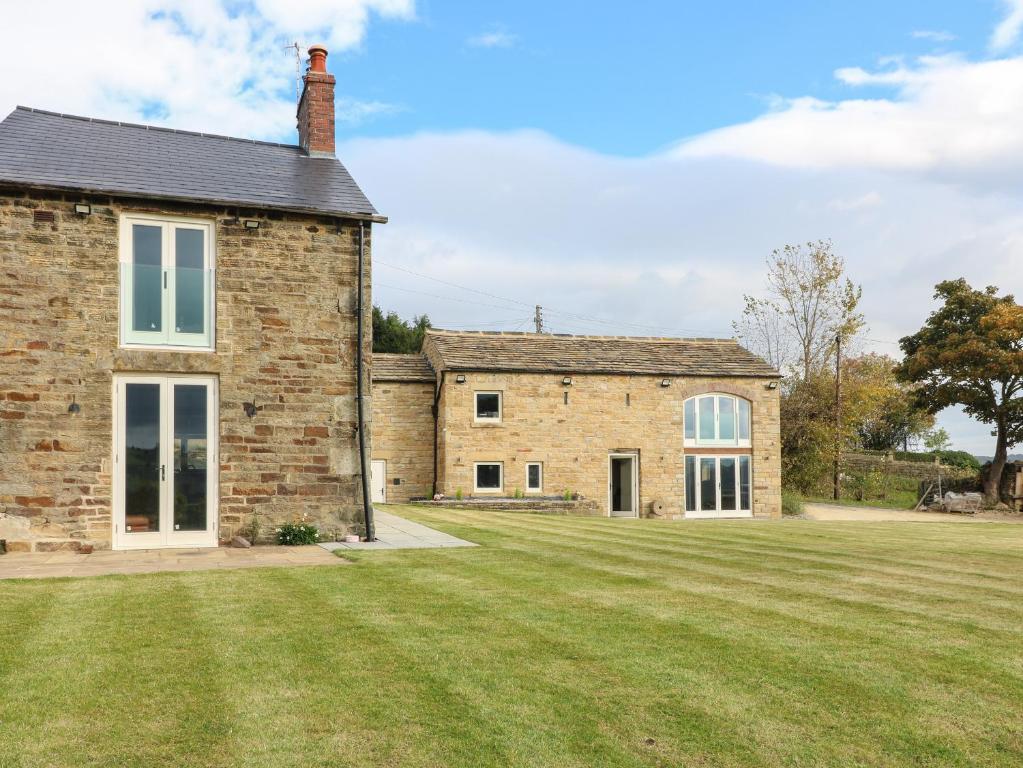 an old brick house with a large grass yard at Top Hill Farm Cottage in Sheffield