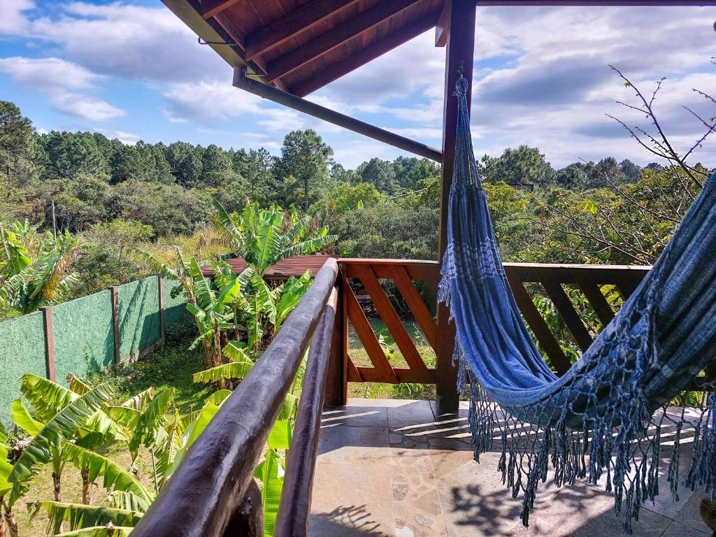 a hammock on a porch with a view of the forest at Pousada Raízes da Guarda in Guarda do Embaú