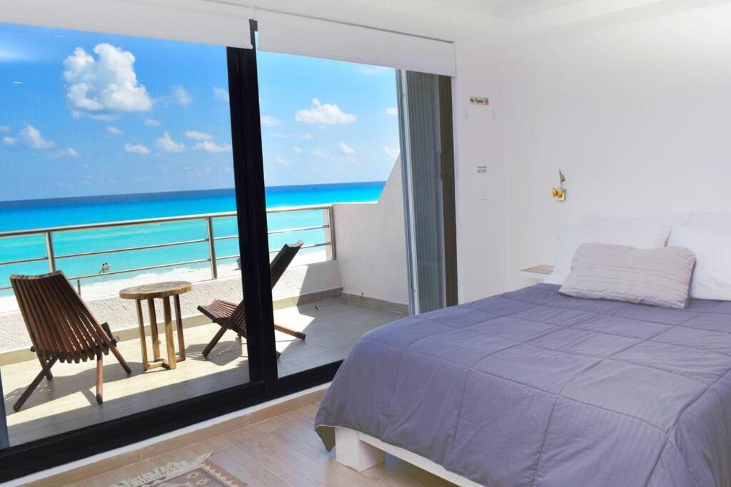 um quarto com uma cama e uma varanda com o oceano em Ocean front Villa Marlin, best location in hotel zone #109 em Cancún