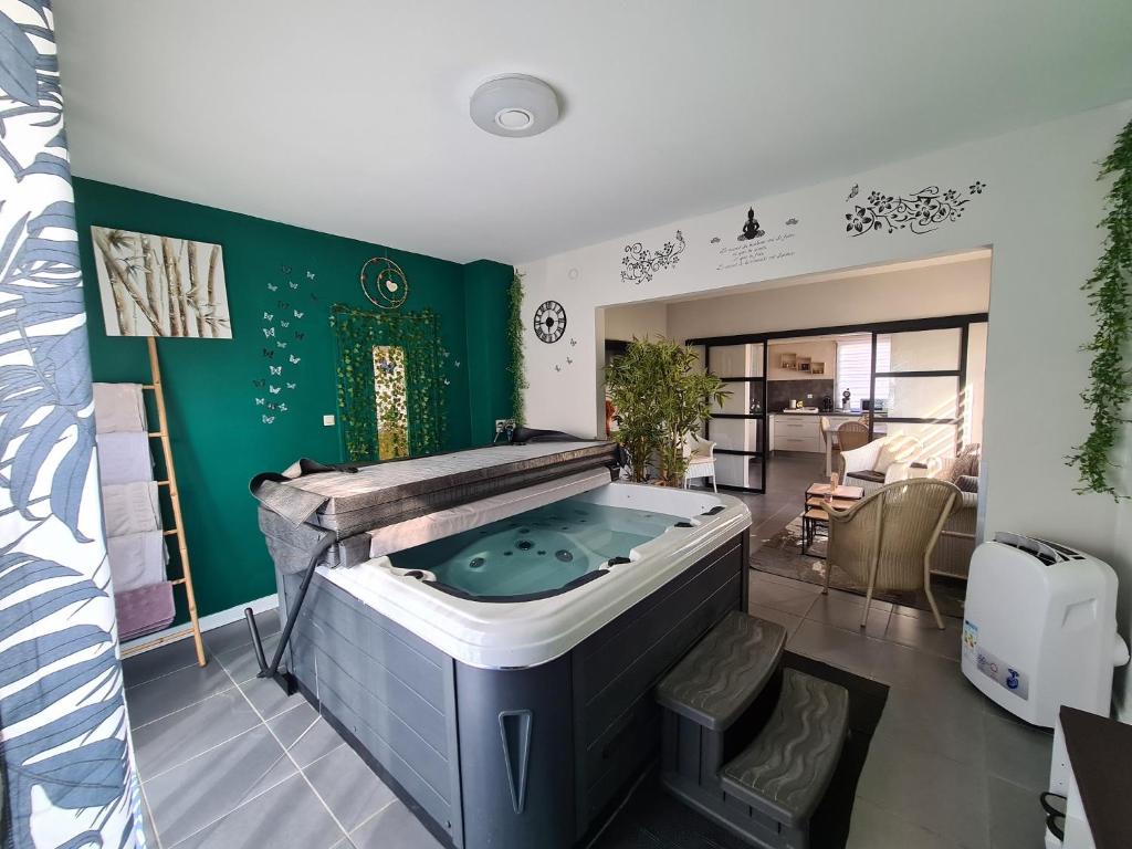 eine Whirlpool-Badewanne in einem Zimmer mit grüner Wand in der Unterkunft Villa Beau Site in Saint-Maurice