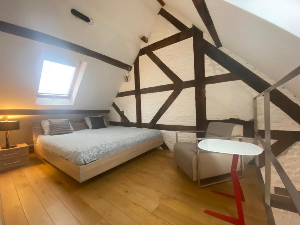 a bedroom with a bed and a table and a window at TRIPLEX NEUVICE in Liège