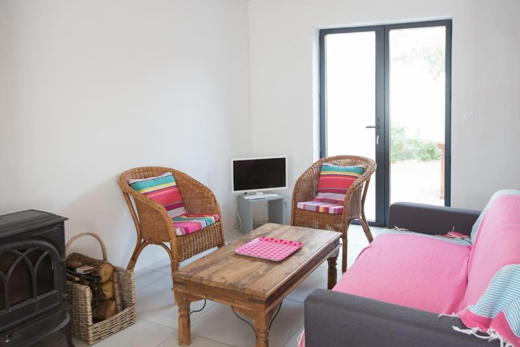 un soggiorno con divano e tavolo di Les Maisons de l'Olivette a La Couarde-sur-Mer
