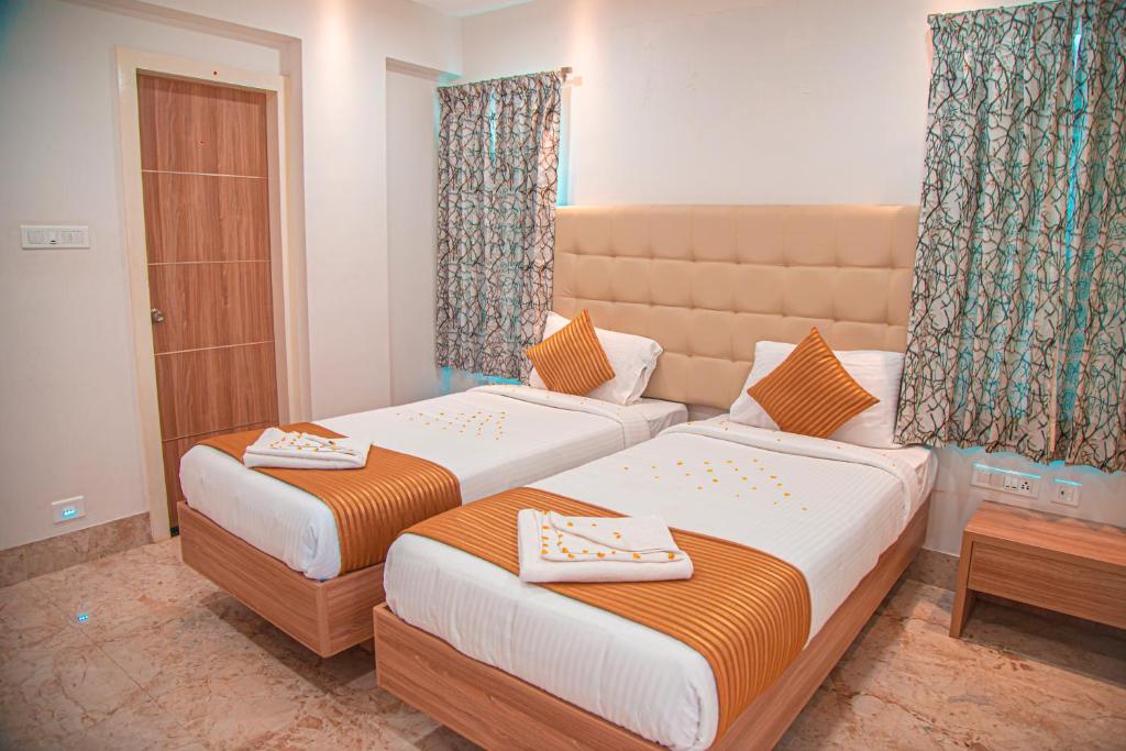 two beds in a hotel room withskirts at Park Avenue Suites in Coimbatore