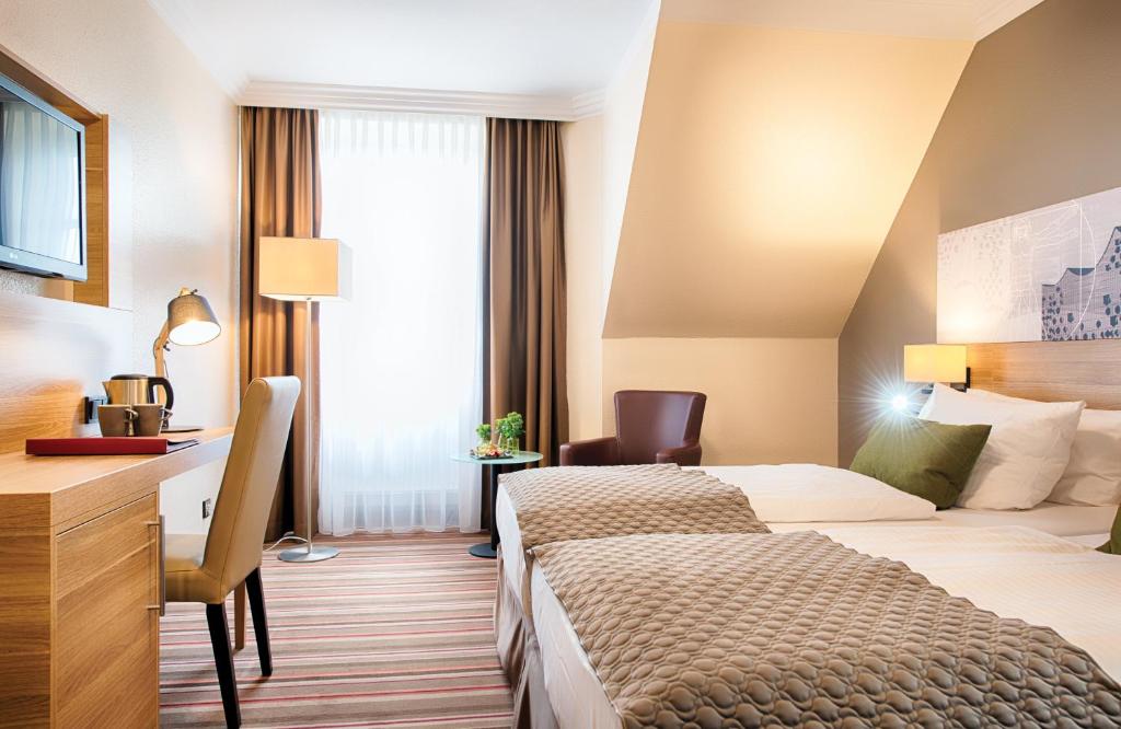 Postel nebo postele na pokoji v ubytování Leonardo Hotel Hamburg Stillhorn