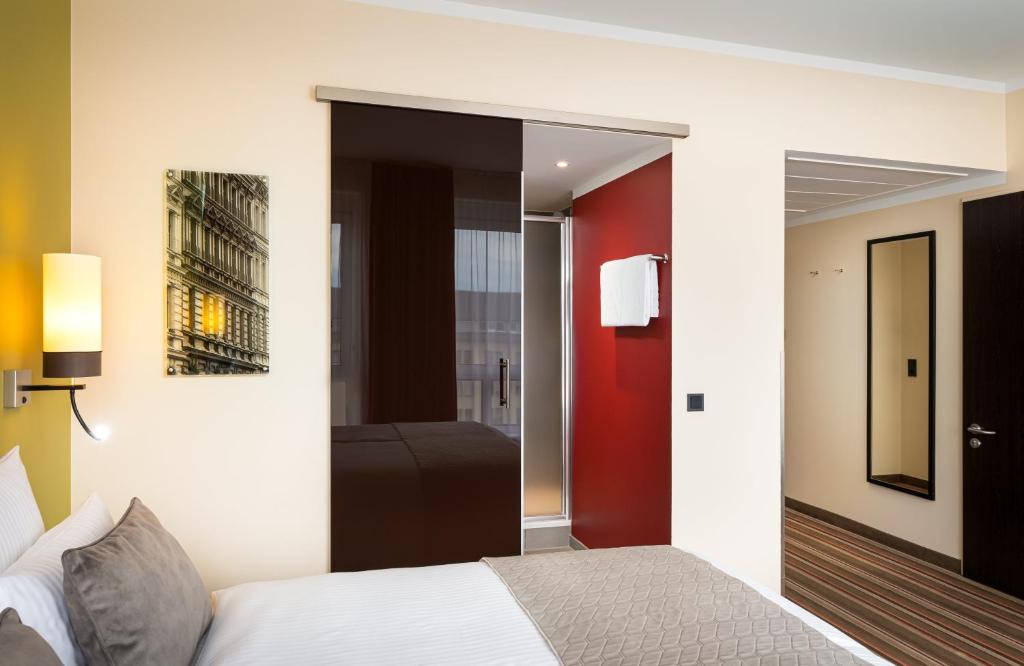 Postel nebo postele na pokoji v ubytování Leonardo Hotel Berlin