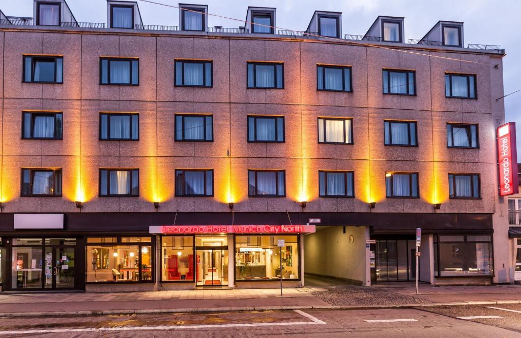 un edificio de ladrillo con luces amarillas. en Leonardo Hotel Munich City North en Múnich