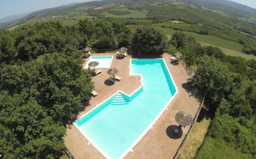 een uitzicht over een zwembad in een veld bij Borgo di Monte Murlo in Guardistallo