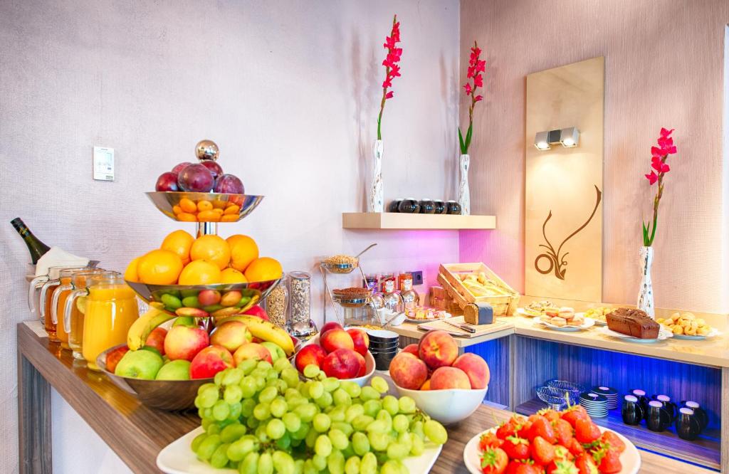 a buffet with bowls of fruit on a table at Leonardo Boutique Hotel Munich in Munich