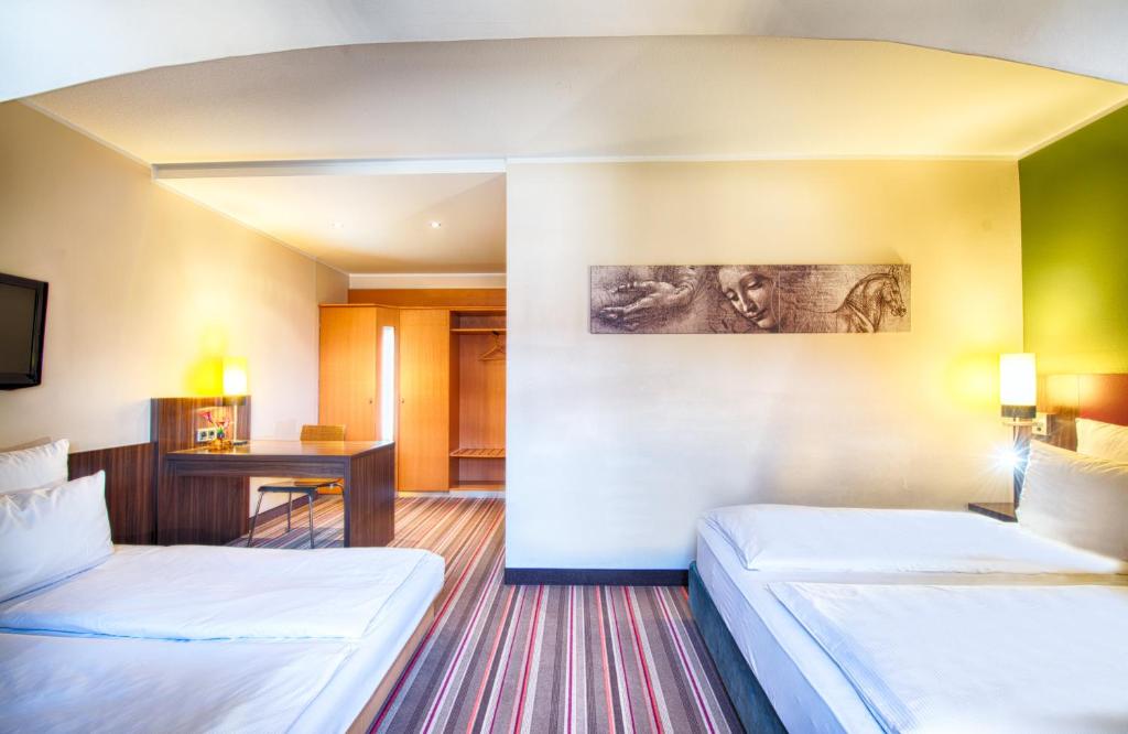 Postel nebo postele na pokoji v ubytování Leonardo Hotel & Residenz Muenchen