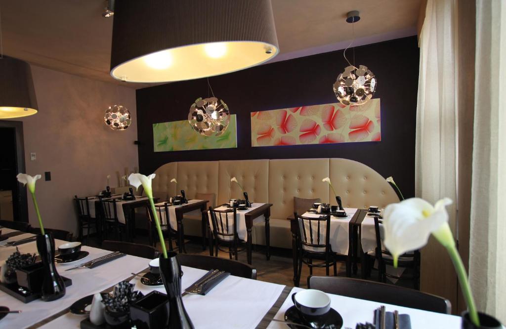 a dining room with tables and chairs with white flowers at Leonardo Boutique Hotel Munich in Munich