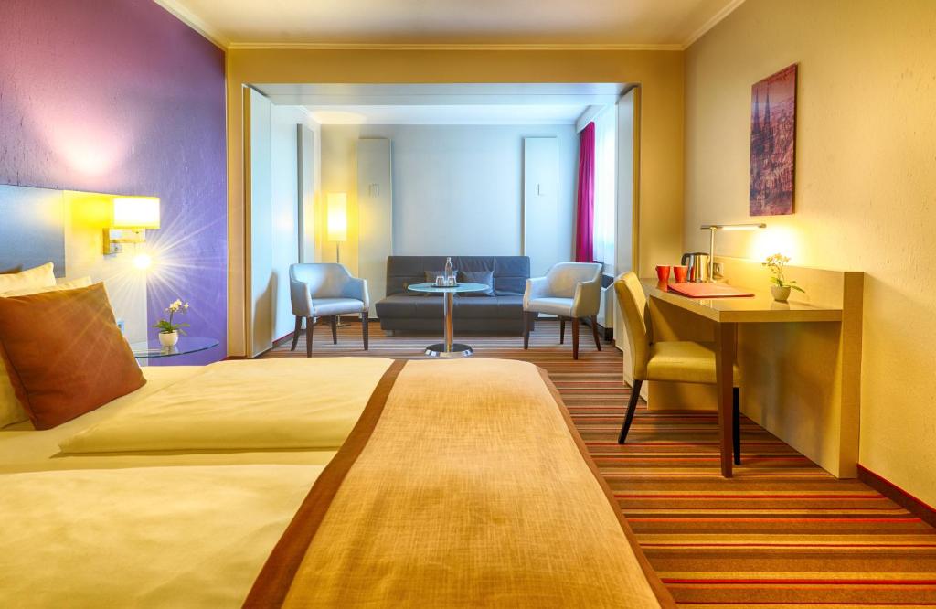 Postel nebo postele na pokoji v ubytování Leonardo Hotel Köln