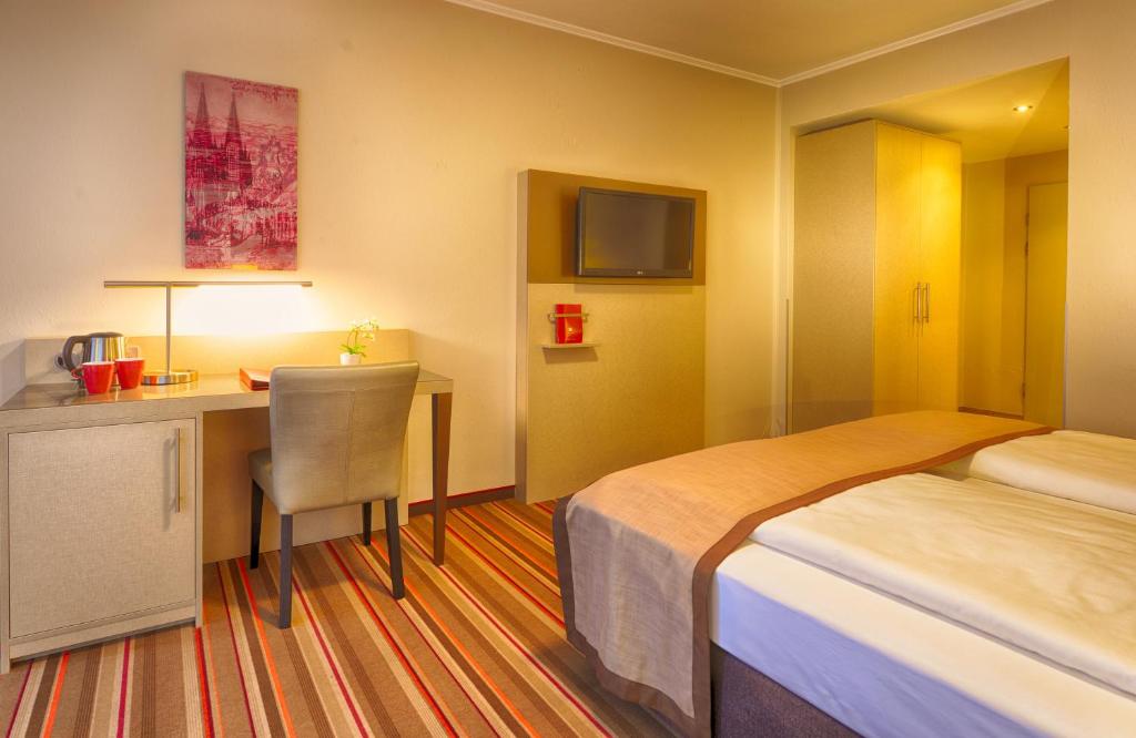 Postel nebo postele na pokoji v ubytování Leonardo Hotel Köln