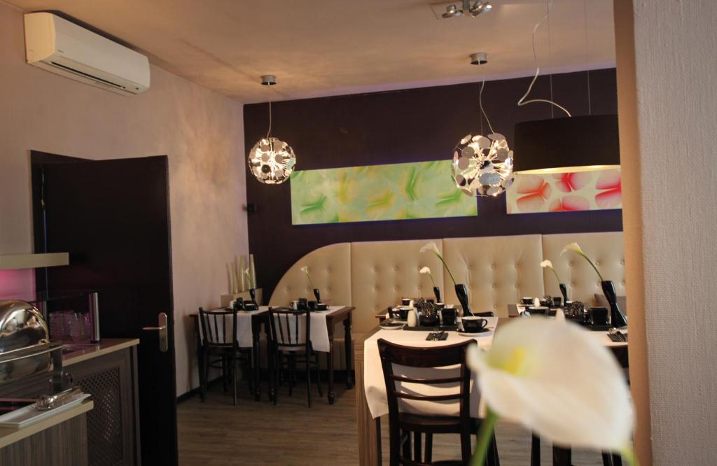 a dining room with tables and chairs and chandeliers at Leonardo Boutique Hotel Munich in Munich
