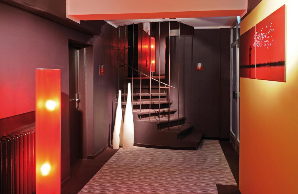 a hallway with red walls and stairs in a building at Leonardo Boutique Hotel Munich in Munich