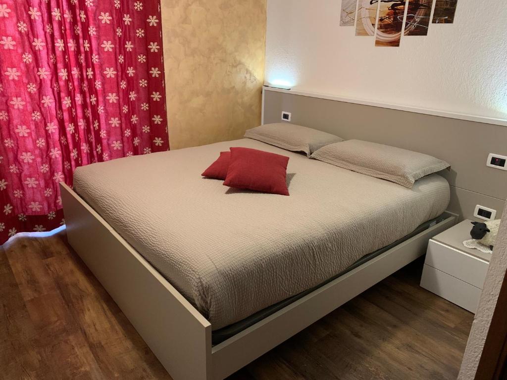 アオスタにあるLa Maison de Pagan Alloggio ad uso turistico VDA CHARVENSOD n 0021のベッドルーム1室(赤い枕付きのベッド1台付)